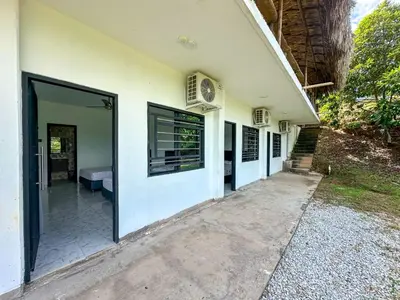 a white building with doors and windows on it at Parcela la cascada in Doradal