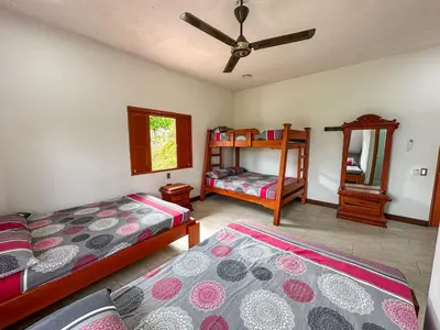a bedroom with two beds and a ceiling fan at Parcela la cascada in Doradal