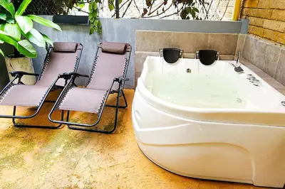 two chairs and a bathtub with two chairs next to it at Monet Luxury Loft in Medellín