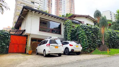 two white cars parked in front of a house at Monet Luxury Loft in Medellín