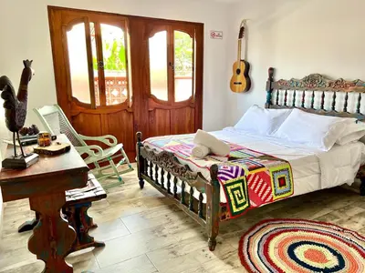 a bedroom with a bed and a table and a guitar at Paisa Territory Jardin in Jardin