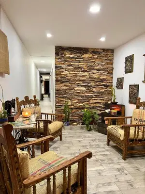a room with tables and chairs and a stone wall at Paisa Territory Jardin in Jardin
