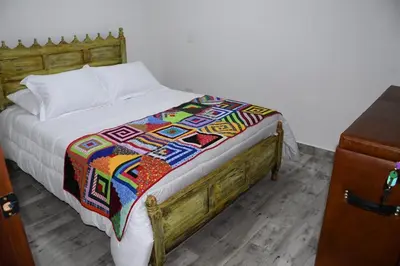 a bed with a colorful blanket on top of it at Paisa Territory Jardin in Jardin