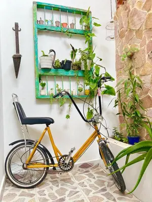 a yellow bike parked next to a wall with plants at Paisa Territory Jardin in Jardin