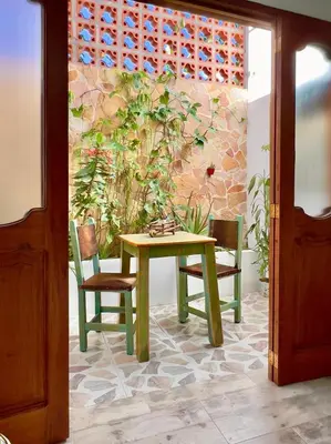 a table and two chairs and a wall with plants at Paisa Territory Jardin in Jardin