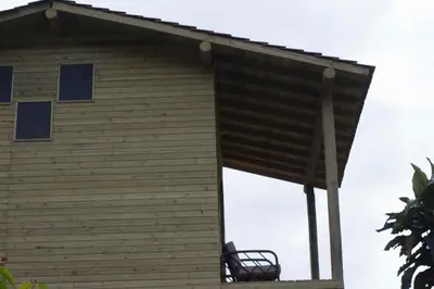 a large wooden building with a porch at Camelia Hostel in San Carlos