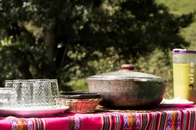 a table with a pot and glasses on a table at Camelia Hostel in San Carlos
