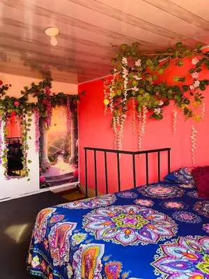 a bedroom with a bed with flowers on the wall at El eden in Manizales
