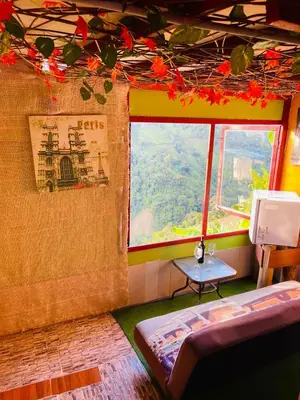 a room with a window and a bed and a table at El eden in Manizales