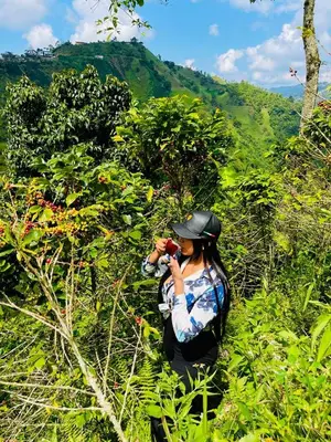 a woman taking a picture of a hill with a camera at El eden in Manizales