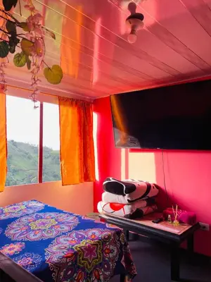 a bedroom with a bed and a flat screen tv at El eden in Manizales