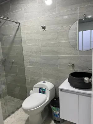 a bathroom with a toilet and a glass shower at Black and White Mariquita Tolima in Mariquita