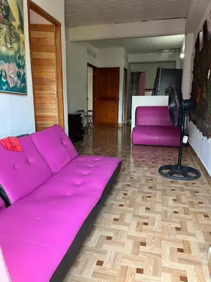 a large purple couch in a room with a fan at Apartamento Barbie 3 in Mutatá