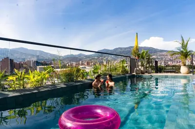 two people in a swimming pool with a purple frisbee at Los Patios Cool Living in Medellín