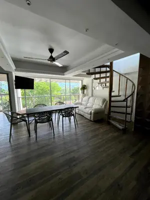 a living room with a couch and a table and chairs at Duplex con jacuzzi y terraza privada in Santa Fe de Antioquia