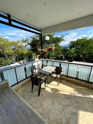 a patio with a table and chairs on a balcony at Duplex con jacuzzi y terraza privada in Santa Fe de Antioquia