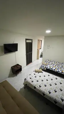 a bedroom with two beds and a flat screen tv at Aparta-estudio amoblado en Medellin, Campo Valdes in Medellín