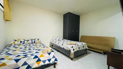 a bedroom with two beds and a couch in it at Aparta-estudio amoblado en Medellin, Campo Valdes in Medellín
