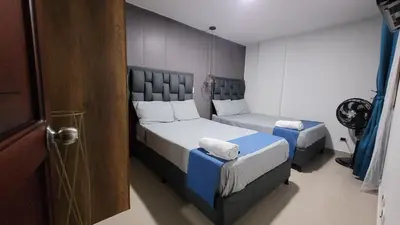 a small bedroom with two beds and a door at ANDALIVING NIQUIA Apartaestudio in Bello