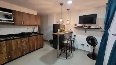 a kitchen with a refrigerator and a counter with stools at ANDALIVING NIQUIA Apartaestudio in Bello