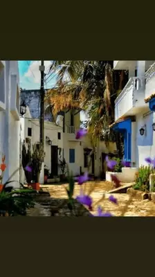 a group of buildings with purple flowers in front of them at Cabaña 41, aldea Doradal Santorini Colombiano in Puerto Triunfo