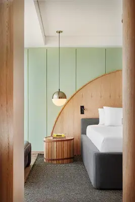 a bedroom with a bed and a wooden headboard at Wellcomm Spa & Hotel in Medellín