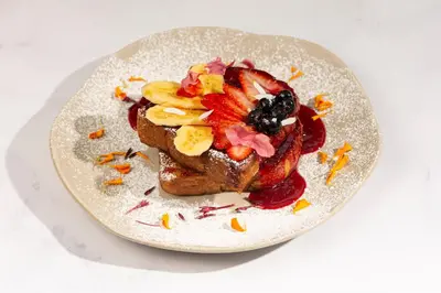 a plate with a piece of bread with fruit on it at Wellcomm Spa & Hotel in Medellín