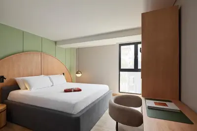 a hotel room with a bed and a chair at Wellcomm Spa & Hotel in Medellín