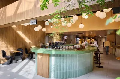 a bar in a restaurant with people walking around at Wellcomm Spa & Hotel in Medellín
