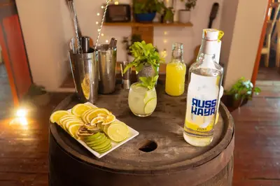 a wooden table with a bottle of juice and lemons at Hotel Colonial Abejorral in Abejorral
