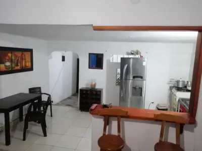 a kitchen with a refrigerator and a table in it at Casa de relajación low cost! in La Dorada