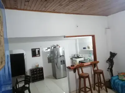 a kitchen with a refrigerator and two bar stools at Casa de relajación low cost! in La Dorada