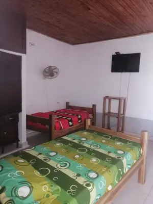 a bedroom with two beds and a flat screen tv at Casa de relajación low cost! in La Dorada