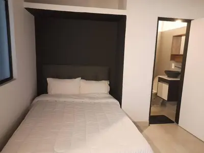 a bedroom with a bed with a black headboard and a mirror at Tribu Medellin House in Medellín