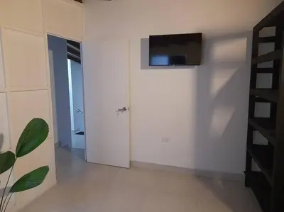 a living room with a television on a wall at Tribu Medellin House in Medellín