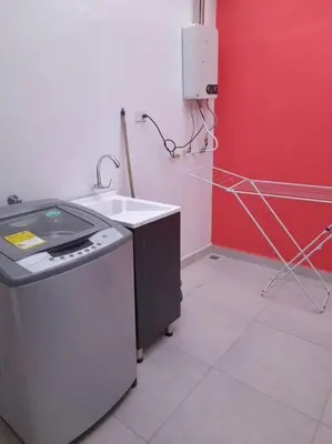 a kitchen with a sink and a stove in a room at Tribu Medellin House in Medellín