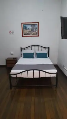 a bed with two blue pillows in a room at HOTEL GIRASOLES in Manizales