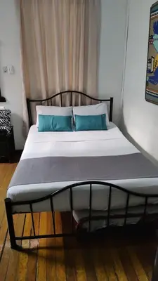 a bed with blue pillows in a room at HOTEL GIRASOLES in Manizales