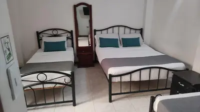 a bedroom with two beds and a mirror at HOTEL GIRASOLES in Manizales