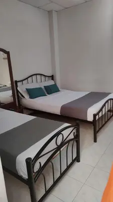 two beds sitting next to each other in a room at HOTEL GIRASOLES in Manizales