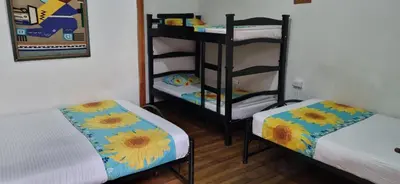 a room with two beds and a bunk bed at HOTEL GIRASOLES in Manizales