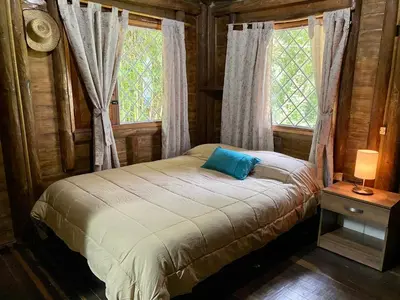 a small bed in a room with a window at Cabaña rústica la Pradera in Guatapé
