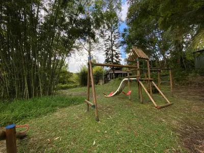 a playground with a slide in the grass at Cabaña rústica la Pradera in Guatapé