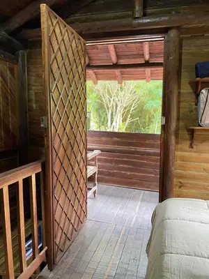 a bedroom in a log cabin with a bed at Cabaña rústica la Pradera in Guatapé