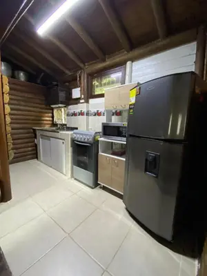 a kitchen with a stainless steel refrigerator in it at Cabaña rústica la Pradera in Guatapé