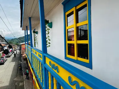 a blue and yellow building with windows and a street at Casa madera in Jardin