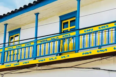 a blue and yellow balcony on a building at Casa madera in Jardin