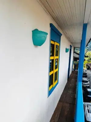 a building with yellow doors and a porch with cars at Casa madera in Jardin
