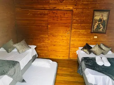two beds in a room with wooden walls at Casa madera in Jardin