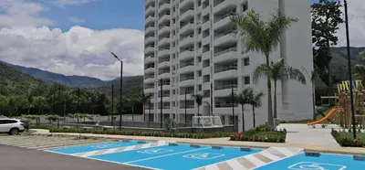 a large apartment building with a playground in a parking lot at Santafé Di sole in Santa Fe de Antioquia